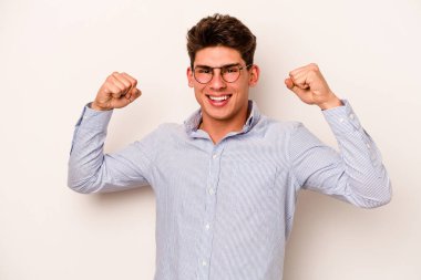 Beyaz arka planda izole edilmiş genç beyaz adam tasasız ve heyecanlı bir şekilde tezahürat yapıyor. Zafer konsepti.