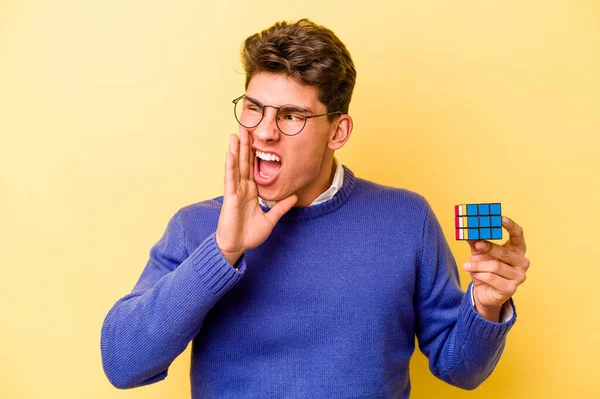 Mladý Běloch Drží Rubiksovu Kostku Izolovanou Žlutém Pozadí Křičí Drží — Stock fotografie