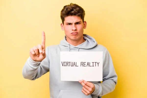Joven Hombre Caucásico Sosteniendo Cartel Virtual Aislado Sobre Fondo Amarillo —  Fotos de Stock
