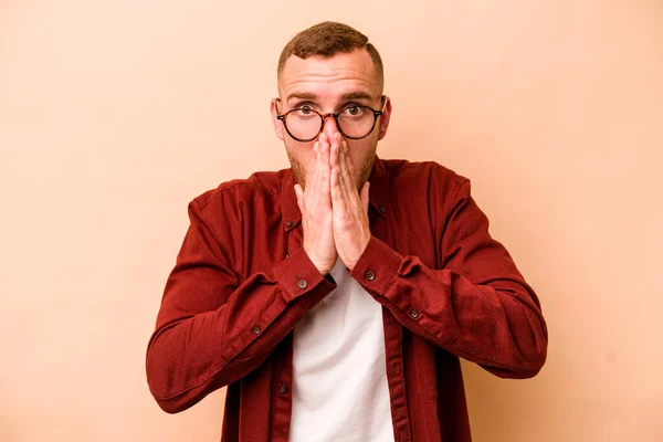 Young Caucasian Man Isolated Beige Background Covering Mouth Hands Looking — Stock Photo, Image