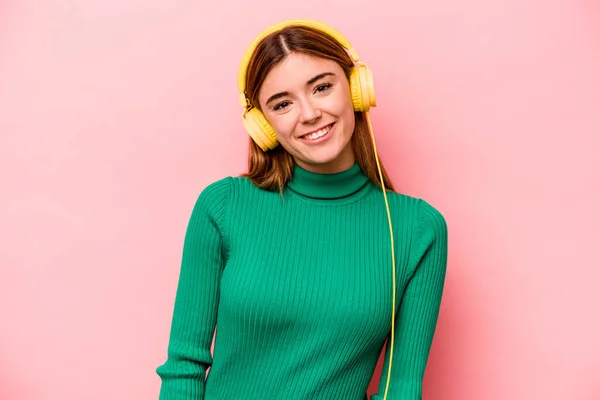 Joven Mujer Caucásica Escuchando Música Aislada Sobre Fondo Rosa Feliz —  Fotos de Stock