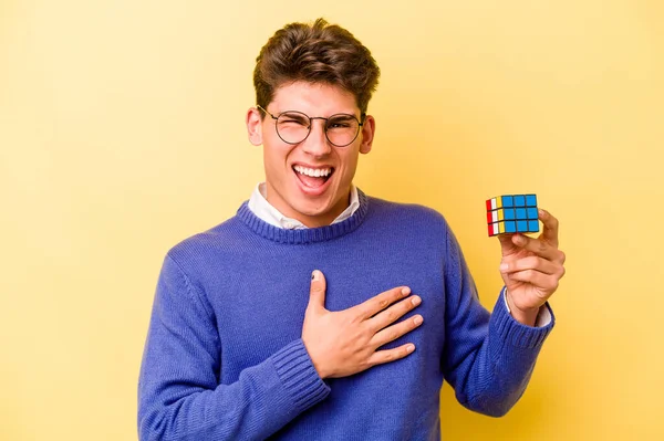 Mladý Běloch Drží Rubiks Kostku Izolované Žlutém Pozadí Hlasitě Směje — Stock fotografie