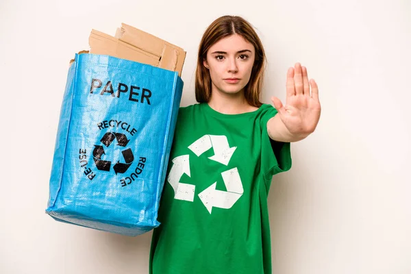 白い背景で隔離された紙をリサイクルするためにリサイクルバッグを持っている若い女性は あなたを防ぐために ストップサインを示す延長手で立って — ストック写真
