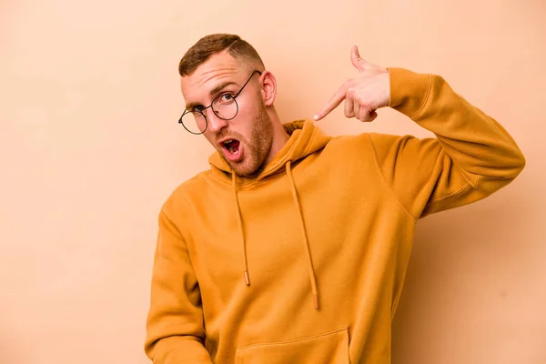 Jonge Blanke Man Geïsoleerd Beige Achtergrond Persoon Wijzend Met Hand — Stockfoto