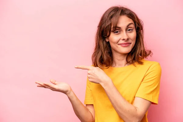 Mulher Branca Jovem Isolado Fundo Rosa Animado Segurando Espaço Cópia — Fotografia de Stock