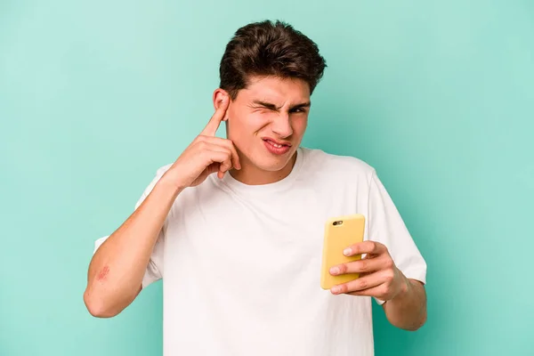 Молодий Білий Чоловік Тримає Мобільний Телефон Ізольований Синьому Фоні Покриваючи — стокове фото