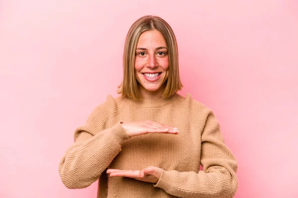 Jonge Blanke Vrouw Geïsoleerd Roze Achtergrond Houden Iets Met Beide — Stockfoto
