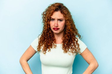 Genç beyaz kadın mavi arka planda izole edilmiş üzgün, ciddi yüz, mutsuz ve hoşnutsuz.