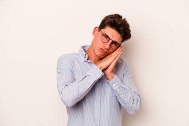 Beyaz arka planda izole edilmiş genç beyaz adam esniyor. Ağzı eliyle kapatan yorgun bir hareket sergiliyor..