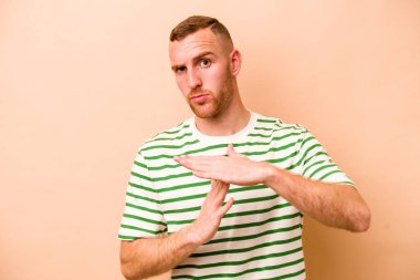 Beyazlı genç bir adam bej arka planda izole edilmiş..