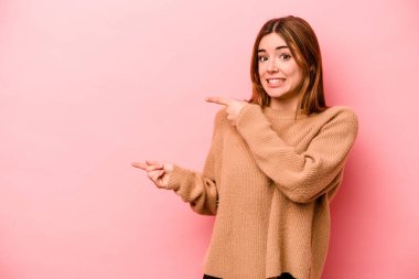 Pembe arka planda izole edilmiş beyaz bir kadın işaret parmağıyla bir fotokopi alanını işaret ederek şok geçirdi..