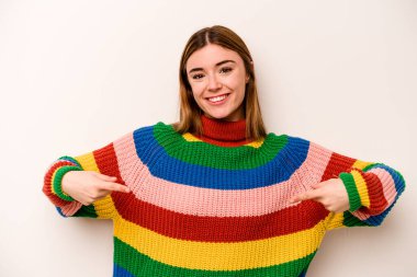 Beyaz arka planda izole genç beyaz kadın parmaklarıyla aşağı noktalar, olumlu duygu.