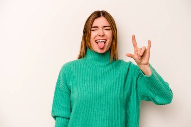 Beyaz arka planda izole edilmiş genç beyaz kadın parmaklarıyla taş hareketi gösteriyor.