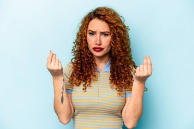 Genç beyaz kadın, mavi arka planda izole edilmiş. Parası olmadığını gösteriyor..