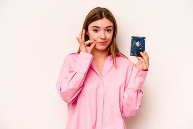 Beyaz arka planda izole edilmiş, dudakları dudaklarında bir sır saklayan genç, gayri resmi beyaz kadın..