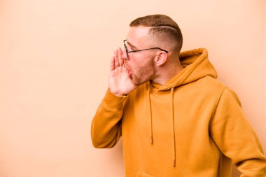 Beyazların arka planında izole edilmiş genç beyaz bir adam gizli bir sıcak fren haberinin olduğunu söylüyor.