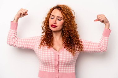 Beyaz arka planda izole edilmiş genç, beyaz tenli bir kadın güçlü bir jest yapıyor, kadınsı gücün sembolü.