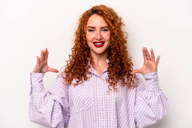 Beyaz arka planda izole edilmiş beyaz tenli genç bir kadın elinde avuç içi bir şeyle kameraya sunuyor..