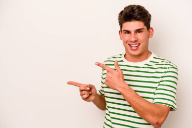 Beyaz arka planda izole edilmiş genç beyaz bir adam işaret parmağıyla fotokopi alanını işaret ederek heyecan ve arzusunu ifade ediyor..