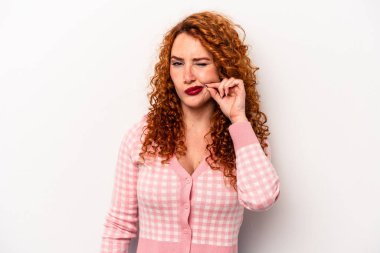 Beyaz arka planda izole edilmiş kızıl saçlı genç bir kadın. Parmakları dudaklarında bir sır saklıyor..