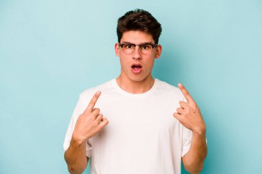 Mavi arka planda izole edilmiş beyaz bir adam ağzı açık bir şekilde üst tarafı işaret ediyor..