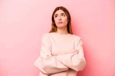 Pembe arka planda izole edilmiş genç beyaz kadın tekrarlanan bir görevden bıktı..