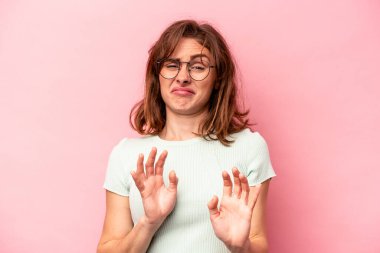 Pembe arka planda izole edilmiş beyaz bir kadın. İğrenme belirtisi gösteren birini reddediyor..