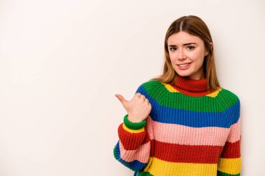 Beyaz arka planda izole edilmiş genç beyaz kadın işaret parmağıyla fotokopi alanını işaret ederek şok oldu..