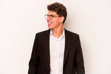 Beyaz arka planda izole edilmiş beyaz iş adamı gülümseyen, neşeli ve keyifli bir tarafa bakıyor..