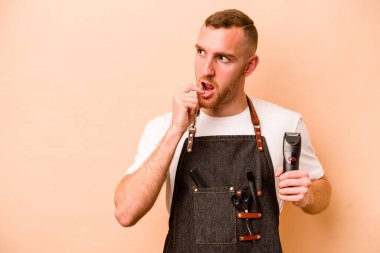 Genç kuaför Kafkasyalı adam bej arka planda izole edilmiş rahat bir şekilde fotokopi odasına bakan bir şey düşünüyor..