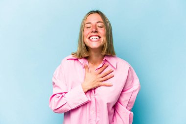 Mavi arka planda yalnız yaşayan beyaz bir kadın elini göğsüne koyduğunda kahkahalar atıyor..