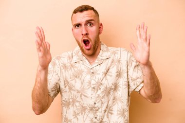 Beyazlı genç bir adam bej arka planda izole edilmiş. Bir fikri, ilham verici bir fikri var..