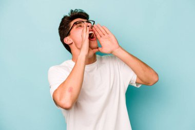 Mavi arka planda izole edilmiş beyaz bir adam heyecanlı bir şekilde bağırıyor..