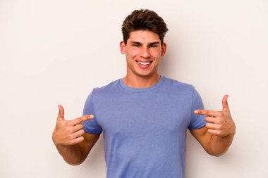 Beyaz arka planda izole edilmiş genç beyaz bir adam parmakları aşağıda, olumlu bir his var..