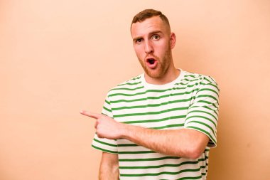 Beyazlı genç bir adam bej arka planda izole edilmiş.