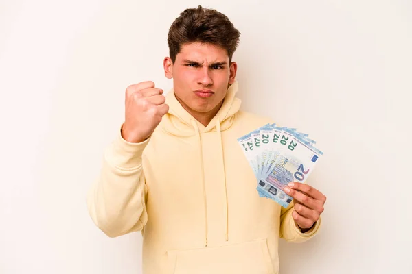 白地に銀行券を持つ若い白人男性がカメラに拳を示す 積極的な顔の表情 — ストック写真
