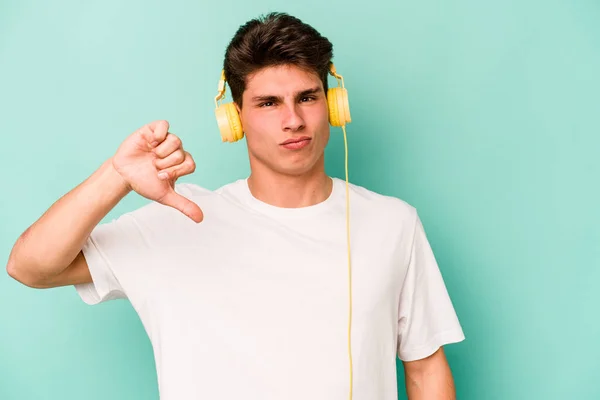 Joven Caucásico Escuchando Música Aislada Sobre Fondo Azul Mostrando Gesto — Foto de Stock