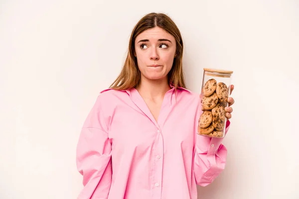 Молода Біла Жінка Тримає Банку Печива Ізольовано Білому Тлі Збентежена — стокове фото