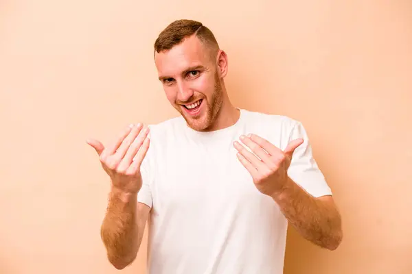 Young Caucasian Man Isolated Beige Background Pointing Finger You Inviting — Stock Photo, Image