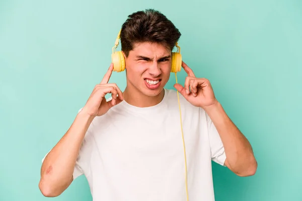Jonge Kaukasische Man Luisteren Naar Muziek Geïsoleerd Blauwe Achtergrond Bedekken — Stockfoto