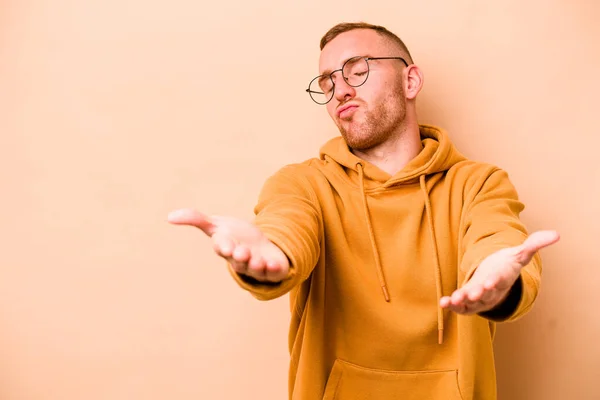 Joven Caucásico Hombre Aislado Beige Fondo Plegable Labios Celebración Palmas — Foto de Stock