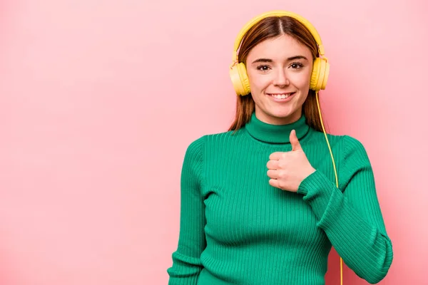 Young Caucasian Woman Listening Music Isolated Pink Background Smiling Raising — Φωτογραφία Αρχείου