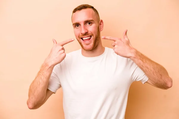 Mladý Běloch Izolovaný Béžovém Pozadí Usmívá Ukazuje Prsty Ústa — Stock fotografie