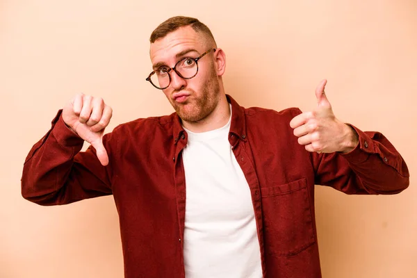 Young Caucasian Man Isolated Beige Background Showing Thumbs Thumbs Difficult — Stock Photo, Image