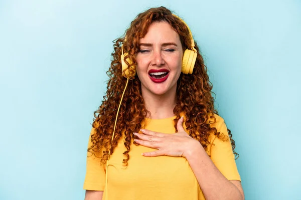 Young Ginger Woman Listening Music Isolated Blue Background Laughs Out — Stock Photo, Image