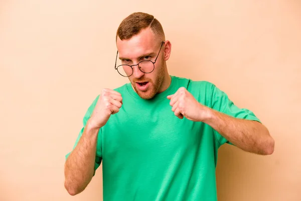 Young Caucasian Man Isolated Beige Background Throwing Punch Anger Fighting — Stock Photo, Image