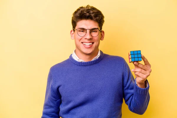 Mladý Běloch Drží Kostku Rubiks Izolované Žlutém Pozadí Šťastný Usmívající — Stock fotografie