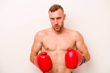 Beyaz arka planda boks yapan genç beyaz bir adam.