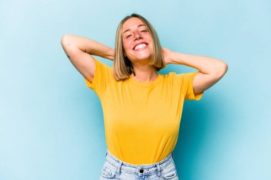 Mavi arka planda izole edilmiş genç beyaz kadın kollarını uzatıyordu, rahat bir pozisyondaydı..