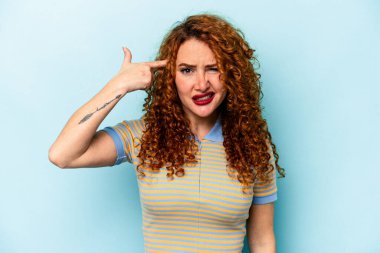 Mavi arka planda izole edilmiş genç, beyaz bir kadın işaret parmağıyla hayal kırıklığı jesti yapıyor..